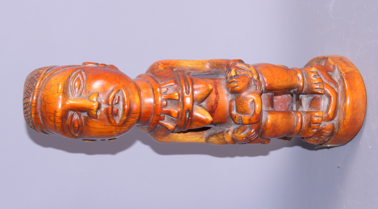 A West African carved ivory figure of a seated woman and child, 11 1/2" high