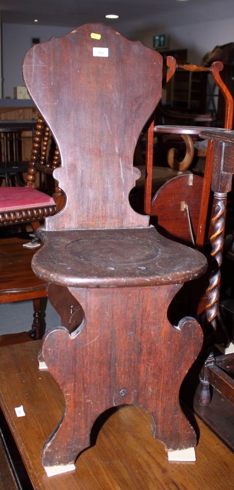 A 18th century William Kent design hall chair with shaped back and dished seat, on shaped panel