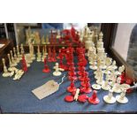 A quantity of red and white ivory chessmen and three part ivory and wooden chess sets