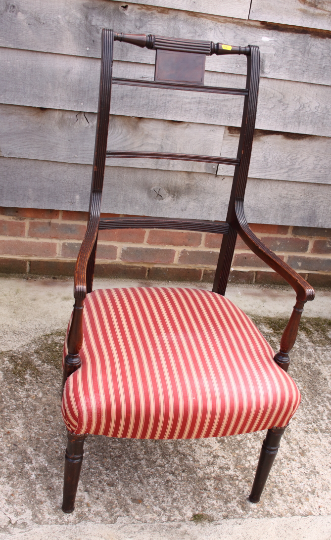 A 19th century mahogany high backed carver chair with reeded arms and red striped seat