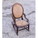A late 19th century walnut framed rocking chair with string seat and back