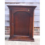 A Georgian oak wall hung corner cabinet with three shaped front shelves enclosed arched panel