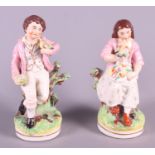 A pair of 19th century Staffordshire pottery figures, children with birds, 8" high (damaged bird
