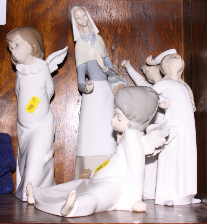 Two Lladro china ornaments of angels and three other Lladro figure ornaments of a woman and two