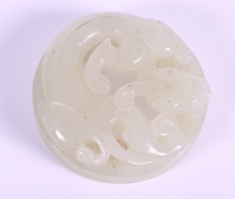 A Chinese carved celadon jade roundel decorated Kylin, 2" dia