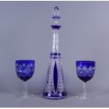 A blue flashed conical decanter with stopper and two similar wine glasses