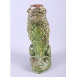 A green glazed terracotta figure of a seated lion, 12" high (damages)