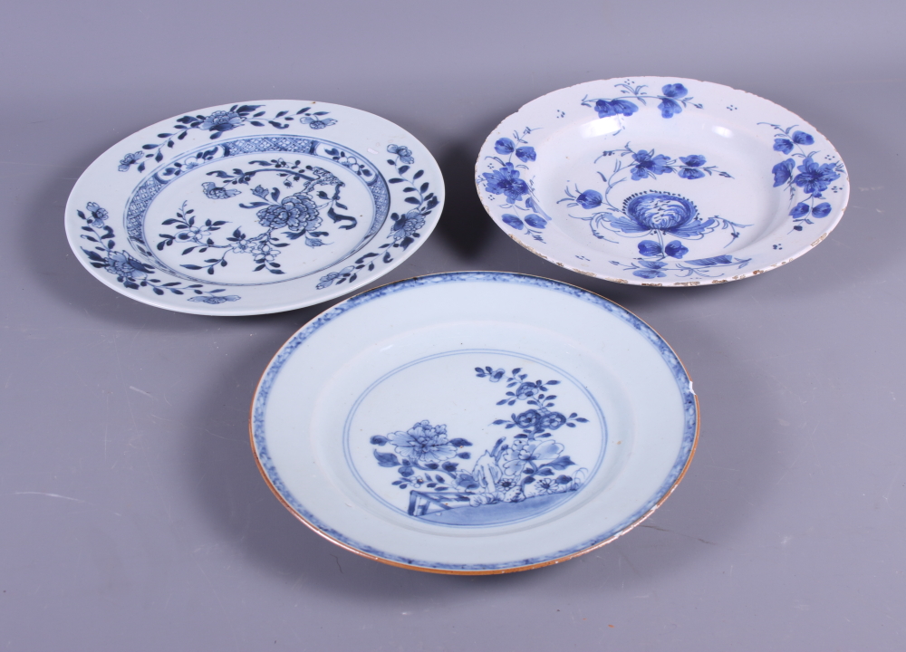 An 18th century Delft floral decorated plate, 9" dia, and two Chinese floral decorated blue and