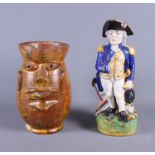 A Staffordshire Nelson Toby Jug, 11" high, and an 18th century terracotta mask jug, 8 1/2" high