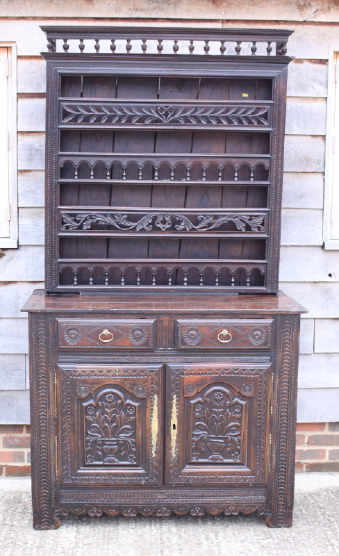 A 19th century Breton carved oak dresser, the upper section fitted four plate racks over two drawers