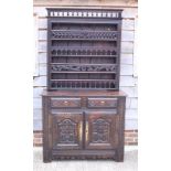 A 19th century Breton carved oak dresser, the upper section fitted four plate racks over two drawers