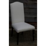 A set of four modern dining chairs with upholstered backs and seats
