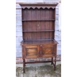 An early 20th century oak dresser with boarded back, fitted two shelves, over base fitted two