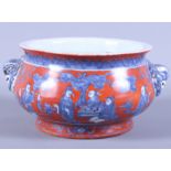 A Chinese porcelain censer decorated with painted figures set in a garden scene, on an iron red