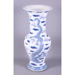 A Chinese blue and white pottery baluster vase with everted rim, decorated with five claw flying