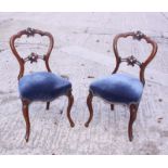 A set of six Victorian walnut balloon back dining chairs with stuffed over seats, upholstered in a