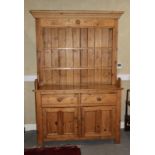 A stripped pine dresser, the upper section fitted two shelves over two drawers and cupboards, on