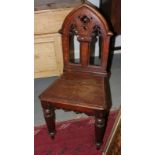 A Victorian oak hall chair with Gothic design back