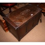 A dark stained 17th century design oak blanket box with three panel front