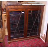An early 20th century mahogany bookcase with blind fretted cornice enclosed two panelled doors,