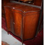 A figured mahogany serpentine front side cabinet enclosed two doors, on square taper supports, 37"
