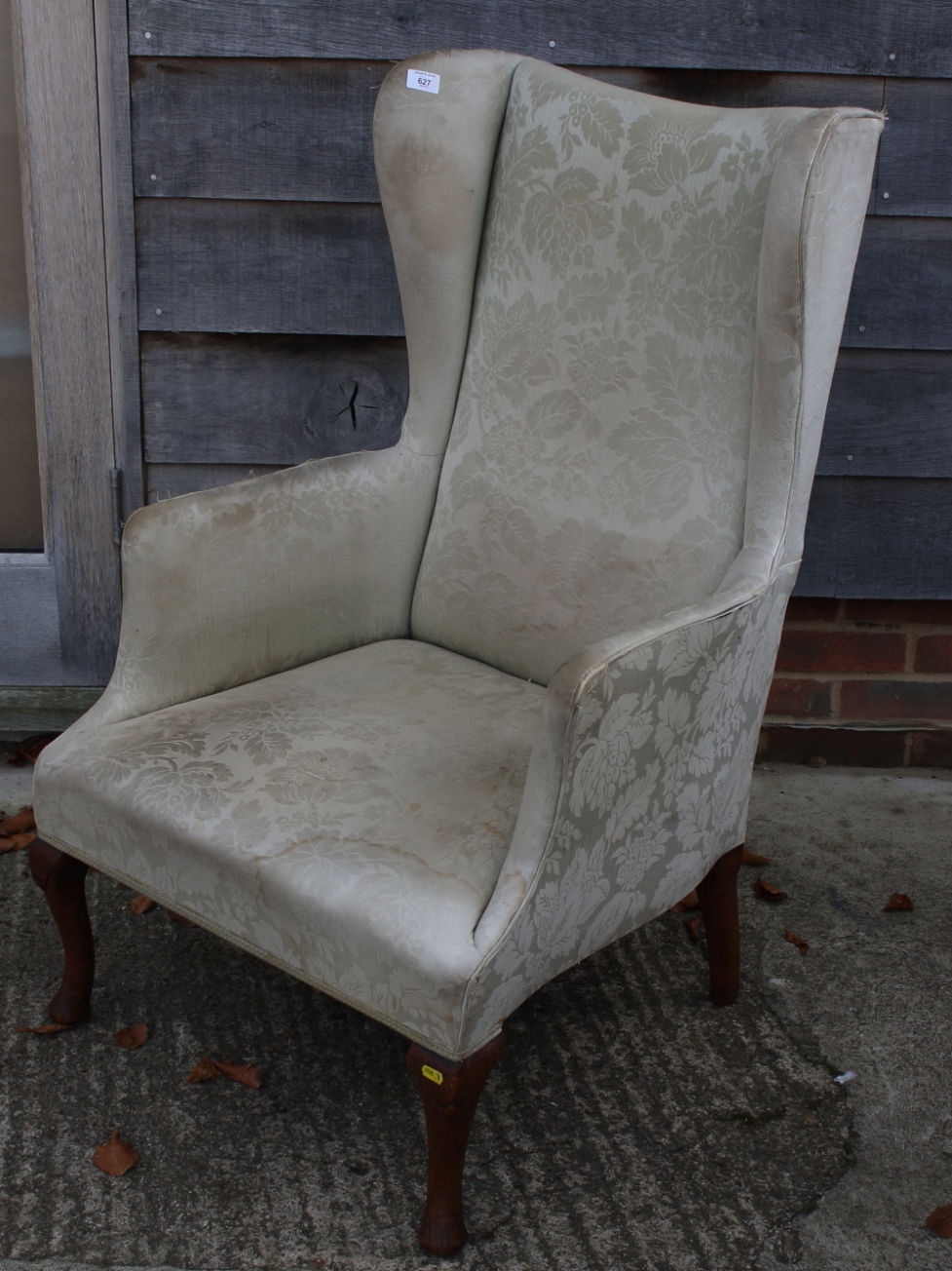 A high wing backed fireside chair, on cabriole supports