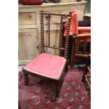 A Victorian nursing chair with red seat panel, on bobbin turned frame