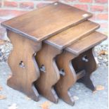 A set of three refectory design oak coffee tables, on panel end supports with pierced trefoils,