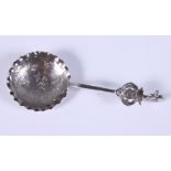 A late 19th/early 20th century Dutch silver loving spoon with shaped bowl engraved with a seated