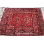 A Bokhara style rug with two medallions on a red ground, 68" x 50" approx