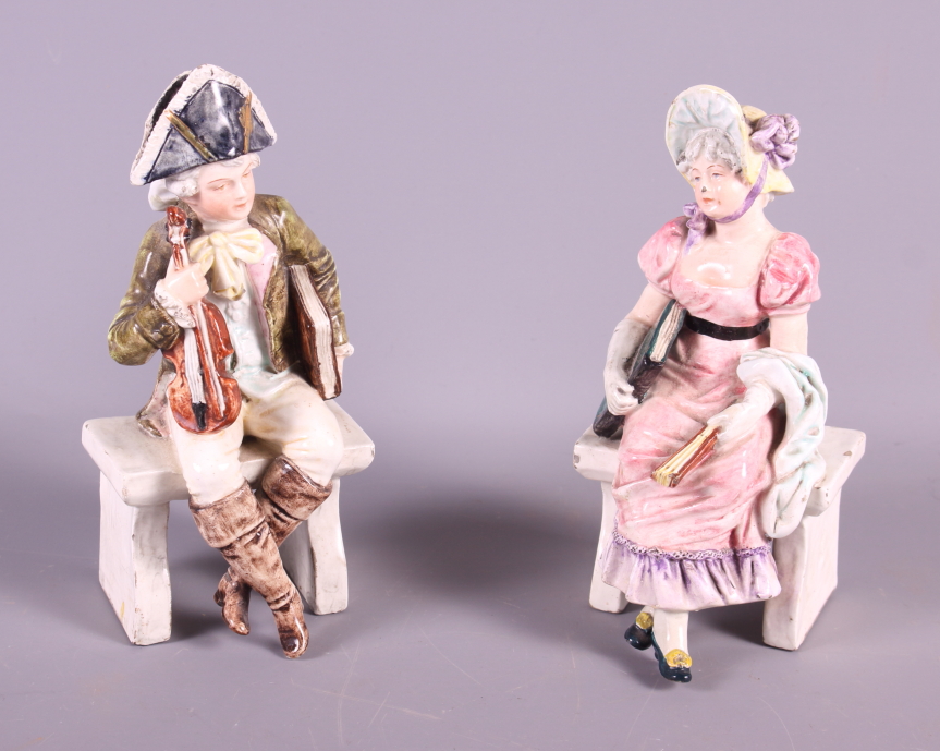 A pair of late 19th century Continental porcelain figures, seated musician and a woman in period