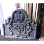 An iron fire back, cast armorial, arched top, 23" x 23", and a brass framed three lap spark guard