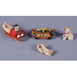 A 1930s German D R P tin-plate toy of a male felt figure laying down on a sleigh and two felt