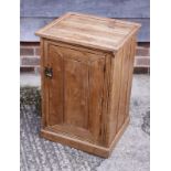 A waxed pine bedside cupboard enclosed panelled door, on block base, 17" wide