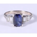 An 18ct white gold and platinum five stone dress ring set central sapphire flanked two baguette