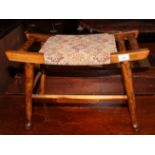 A rectangular stained wood piano stool with bobbin turned side rails