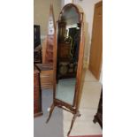 A stained as mahogany cheval dressing mirror with shaped top