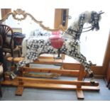 A dapple grey rocking horse, on wooden safety stand