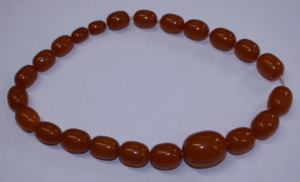 A string of butterscotch amber beads, twenty-three beads ranging in size from 8mm to 28mm approx,