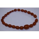 A string of butterscotch amber beads, twenty-three beads ranging in size from 8mm to 28mm approx,