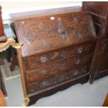 A late 19th century oak bureau with fall flap over three drawers with lion mask handles, 35" wide