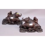 A pair of Chinese carved hardwood water buffalos, each raised on a hardwood stand, 12" long