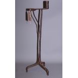 A wrought iron rush light holder/candlestick, on tripod base, 23" high