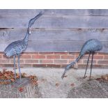 A pair of bronzed garden ornaments of storks, the larger 35" high