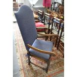 A 17th century design walnut elbow chair with cane panel seat and loose cushion, upholstered in a