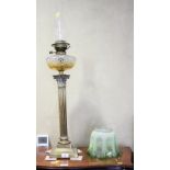 A late 19th century brass Corinthian column oil lamp with cut glass reservoir etched green glass