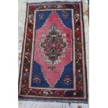 A Persian rug with central medallion on a salmon ground and multi borders, 46" x 26" approx
