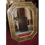 An octagonal bevel plate wall mirror in broad gilt and black frame with leaf and flower