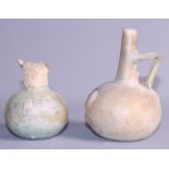 A Roman glass bulbous flask, 4 1/2" high (damages) and a smaller Roman glass flask (damaged rim) 3