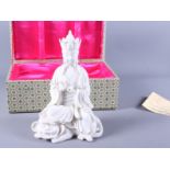 A Chinese blanc-de-chine porcelain figure of a Kuan Yin seated on a dragon, bearing impressed and